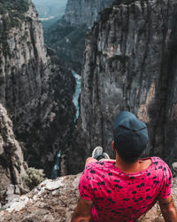 Rear view of woman on rock against mountains