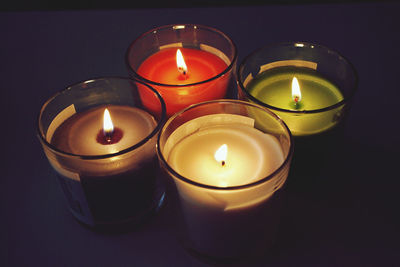 High angle view of illuminated tea light candles in darkroom