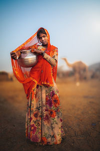 Portrait of woman standing on field