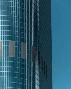 Low angle view of office block against clear blue sky