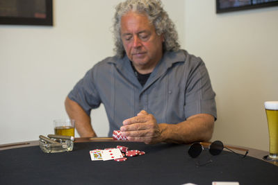 Man playing poker while sitting at table