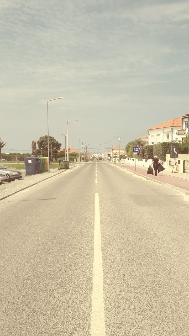 ROAD AMIDST CITY AGAINST SKY