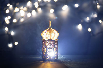 Close-up of illuminated lamp against lighting equipment