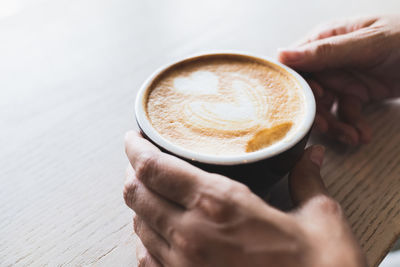 Cropped image of hand holding coffee cup