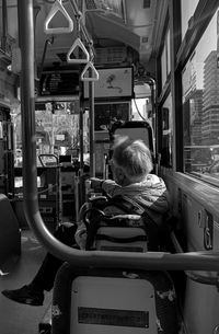 Rear view of woman sitting in bus