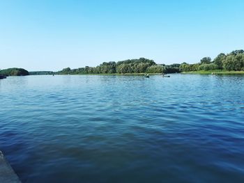 Scenic view of lake against clear blue sky