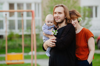 Happy family with baby on playground outdoors