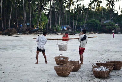 Rear view of people walking on beach