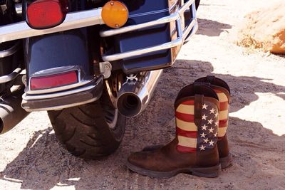 Shoes with american flag on field by motorcycle