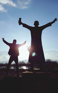 Low angle view of silhouette man standing against sky