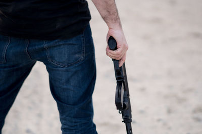 Midsection of man with rifle standing on ground