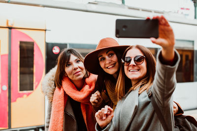 Portrait of happy young woman using mobile phone