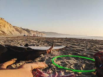 People on beach against clear sky