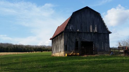 Barn on field against sky