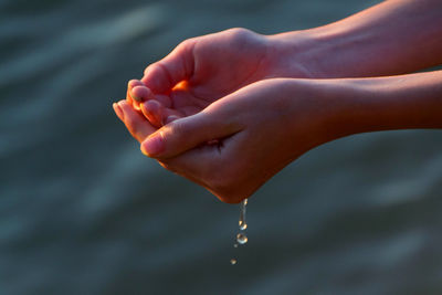 Close-up of water drop falling on hand