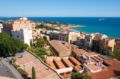 High angle view of townscape by sea against sky