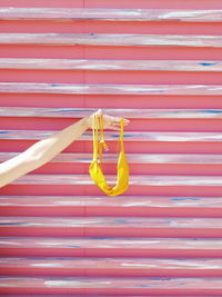 Cropped hand of woman holding bra against steps