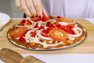 Close-up of hand holding pizza on table