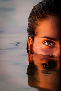 Close-up portrait of a smiling young woman in water