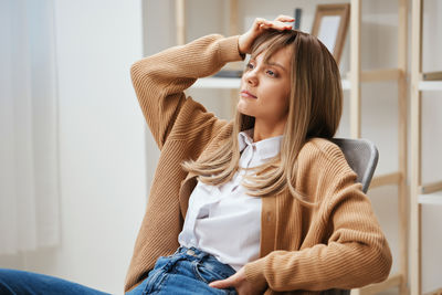 Young woman sitting on sofa at home