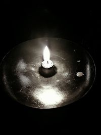 Close-up of lit candle in darkroom