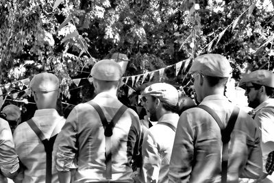 Rear view of people standing against plants