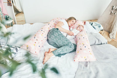 High angle view of woman relaxing on bed at home