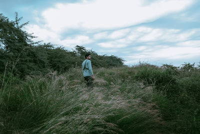 Rear view of person on field against sky