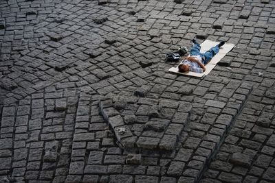 Full length of man lying on cobblestone