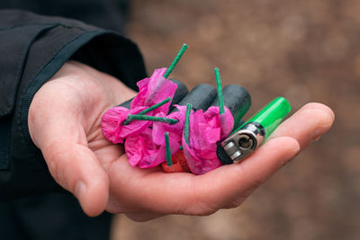 Close-up of hand holding multi colored pencils