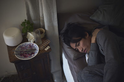 Sad man facing depression lying in bed