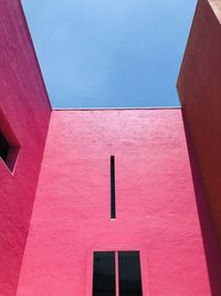 Low angle view of pink building against sky