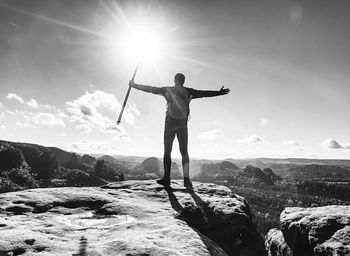 Man in sports clothes with sticks on mountain hill near edge. trekking sticks for nordic walking