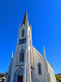 Low angle view of clock tower against blue sky