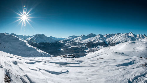 Scenic view of snowcapped mountains against clear blue sky