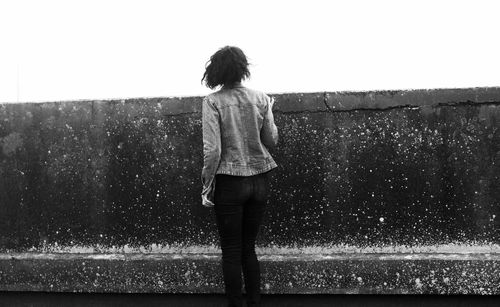 Rear view of woman with umbrella walking in rain