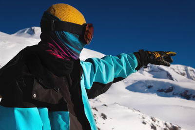 Sportsman pointing with his hand while skiing on a snowy slope. a traveler, a tourist, pointing his