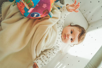Directly above shot of cute baby girl lying on bed at home
