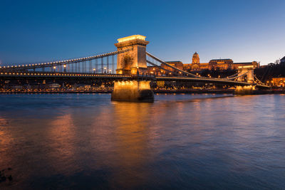 Illuminated chain bridge over danube river in city at night