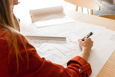 Midsection of woman writing in book