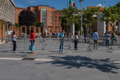 People on street against buildings in city