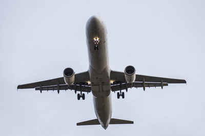 Low angle view of airplane flying against sky