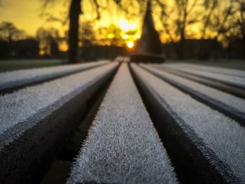 Close-up of railroad track against sky during sunset