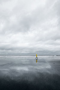 Rear view of man on sea against sky