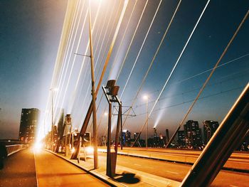 Low angle view of illuminated street against sky at night