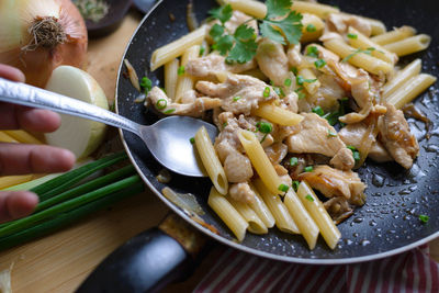 Cropped hand preparing pasta