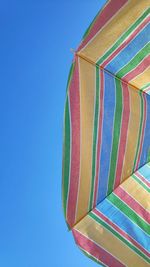 Low angle view of umbrella against clear blue sky