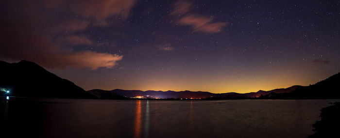 Scenic view of lake against sky at night