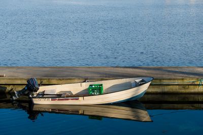 Side view of motor boat anchored near jetty