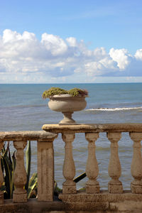 An old vase on the railing of nero's garden looking the sea